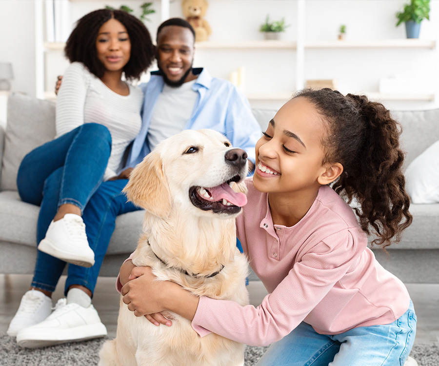 A happy dog sitting with its owners on a restaurant patio